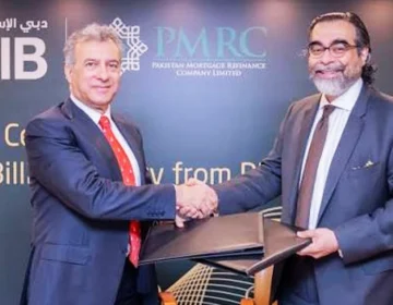 Dubai Islamic Bank Pakistan and PMRC officials exchanging agreement documents for Islamic housing finance deal
