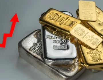 Pure gold bars stack placed alongside silver coins representing gold and silver price increase in Pakistan