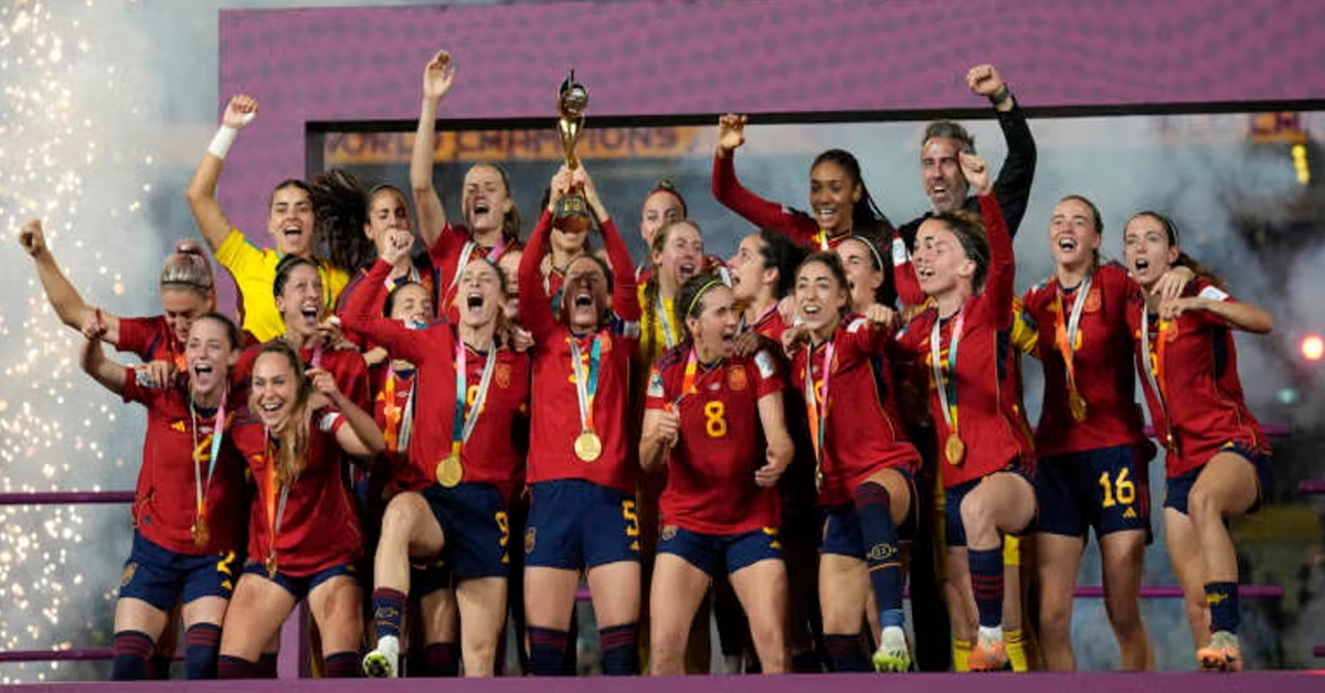 Spanish football players lifting the gold FIFA World Cup trophy in celebration on stage