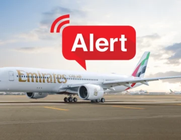 Emirates and flydubai commercial airplanes parked at Dubai International Airport terminal gates.