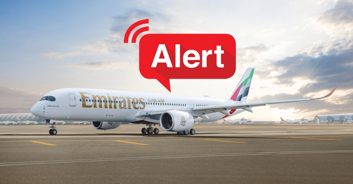 Emirates and flydubai commercial airplanes parked at Dubai International Airport terminal gates.