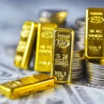 Gold bars and coins on a financial chart background.