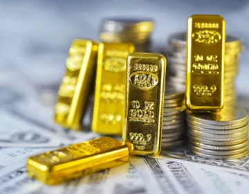 Gold bars and coins on a financial chart background.
