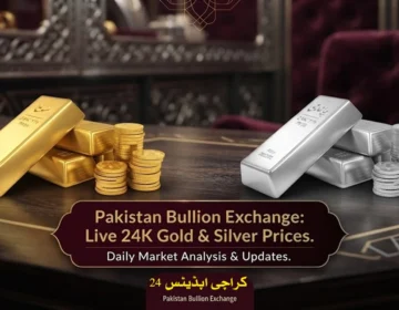 Polished 24K gold bar and silver coins displayed on a dark surface reflecting light.