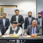 Meezan Bank and LUMS officials exchanging MoU documents at a signing ceremony.