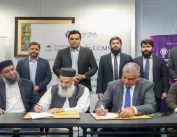 Meezan Bank and LUMS officials exchanging MoU documents at a signing ceremony.