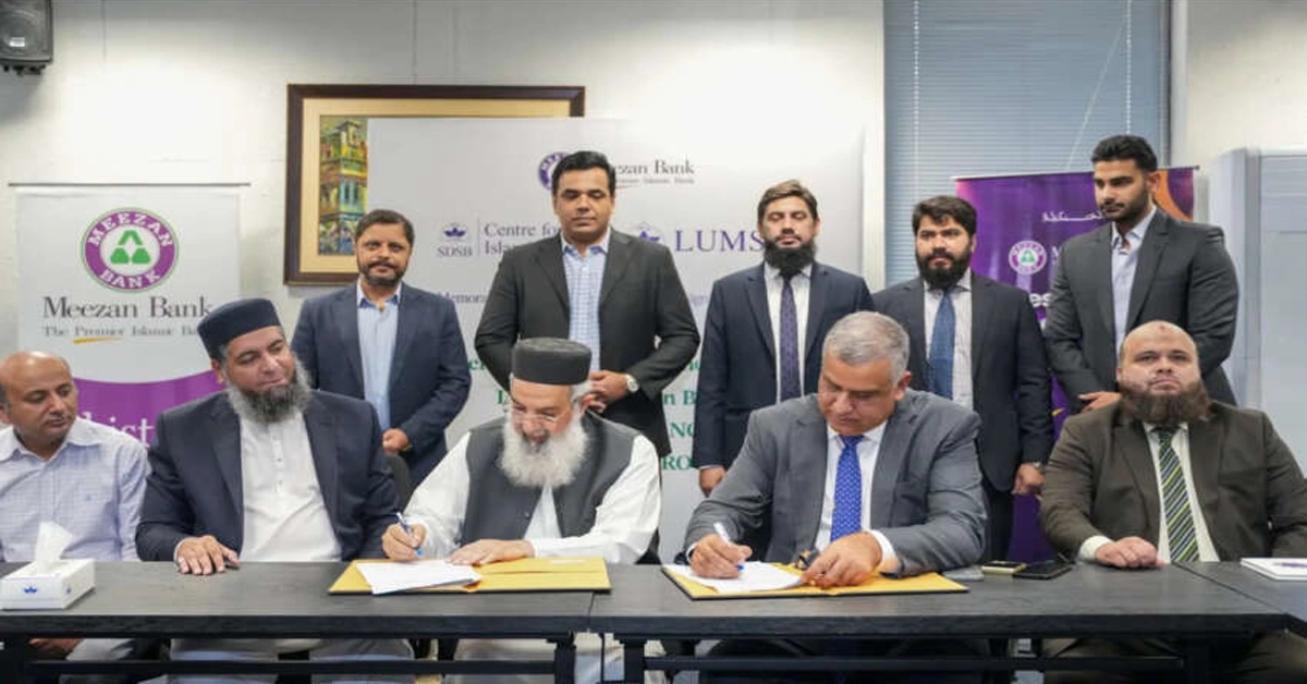 Meezan Bank and LUMS officials exchanging MoU documents at a signing ceremony.