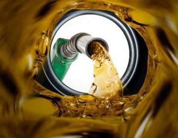 A close up shot of a petrol pump nozzle being placed inside a car fuel tank in Pakistan