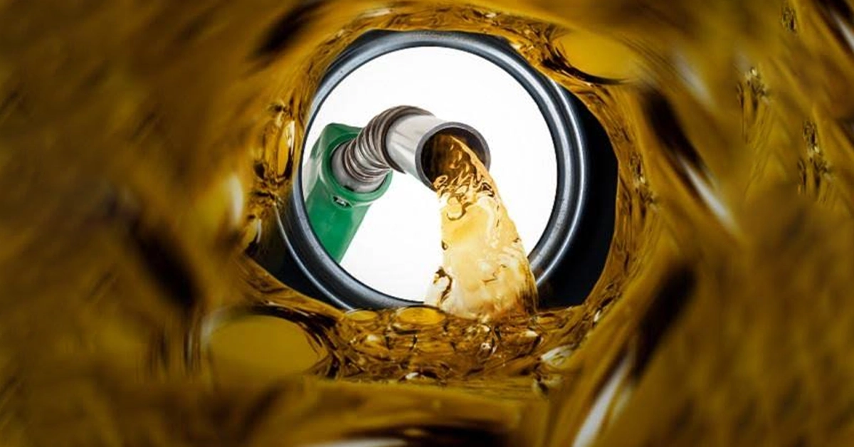 A close up shot of a petrol pump nozzle being placed inside a car fuel tank in Pakistan
