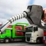 A fuel pump nozzle being operated at a gas station for refueling during fuel price changes in Pakistan