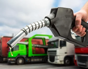 A fuel pump nozzle being operated at a gas station for refueling during fuel price changes in Pakistan