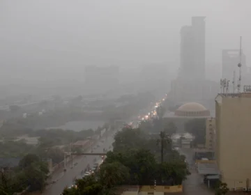 Dark clouds and heavy rain pouring down on Karachi roads and city view