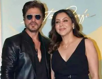 Bollywood actor Shah Rukh Khan and his wife Gauri Khan posing outside a luxury residential property.
