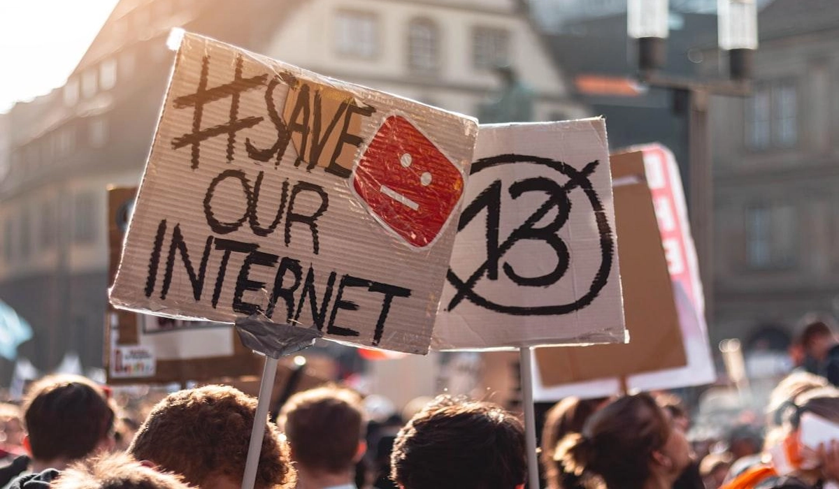 A stylized graphic representing Gen Z youth using smartphones for digital protest hashtags and social media stories
