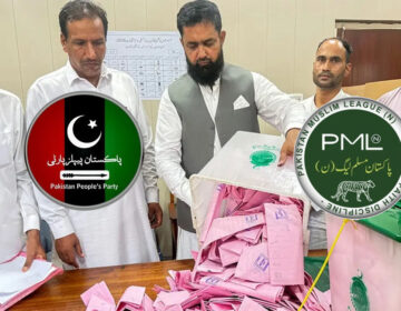 Voters casting ballots at a polling station booth during Azad Jammu Kashmir assembly elections