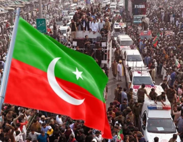 Pakistan Tehreek-e-Insaf workers waving party flags during a protest rally heading towards Islamabad